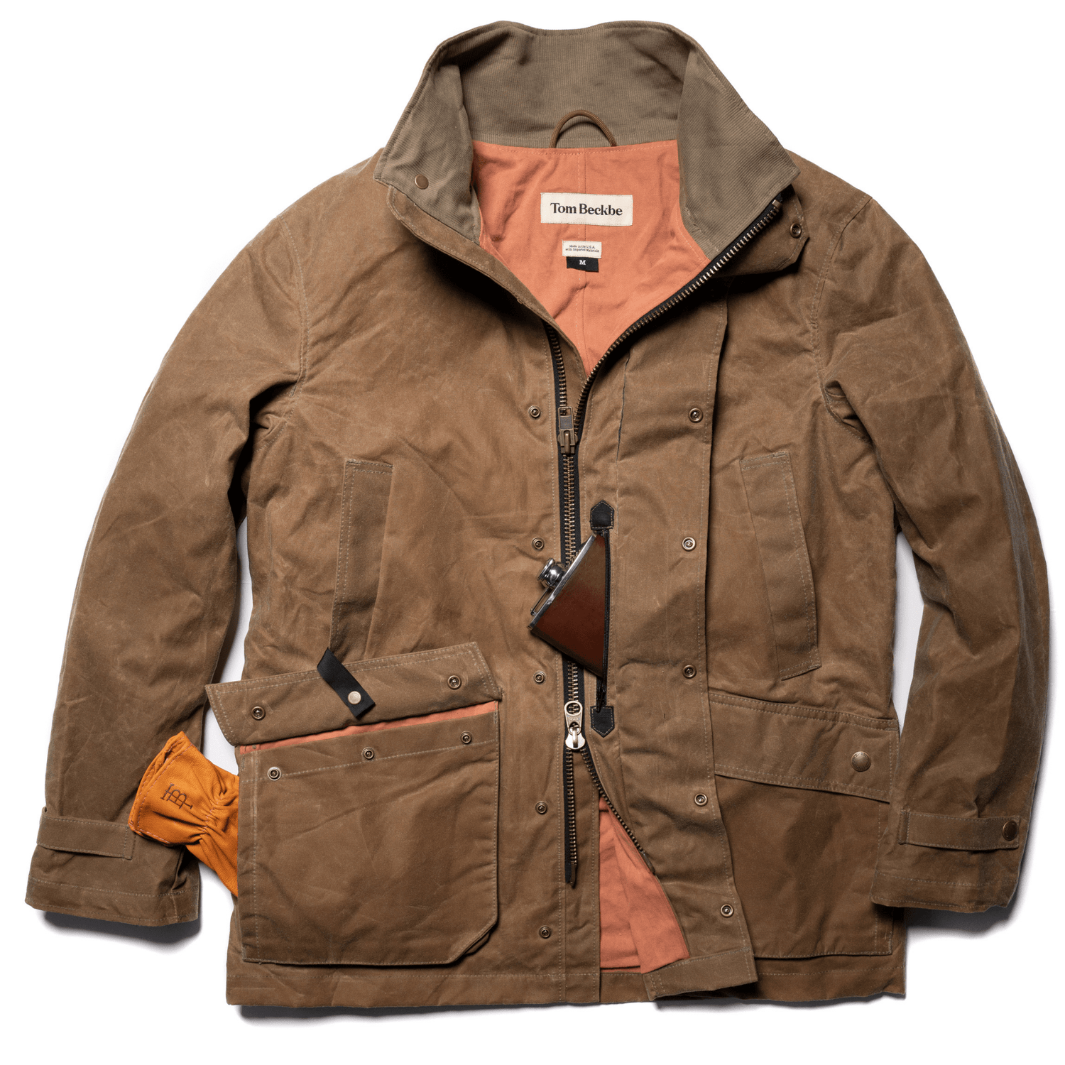 Brown field jacket with a coral lining, featuring a pocket holding tan gloves and a leather wallet on a lanyard.