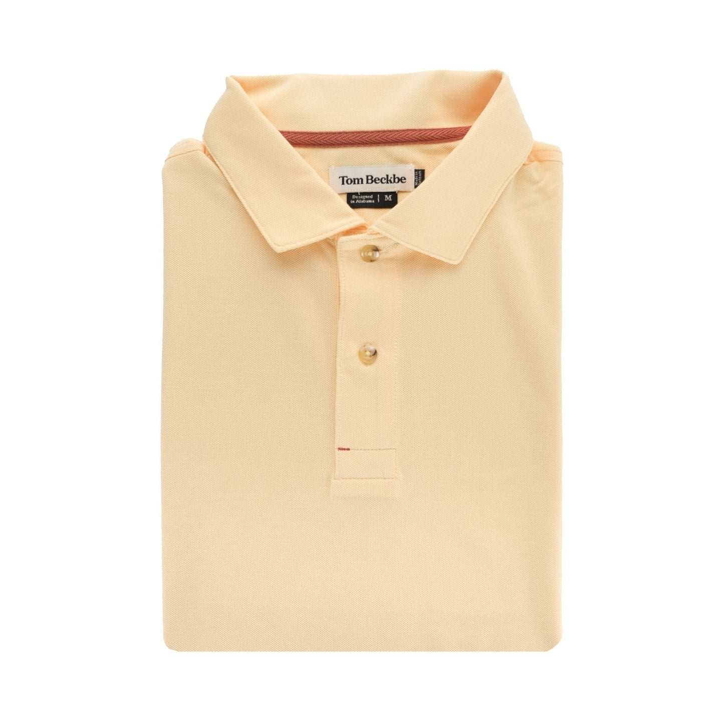 Folded Coastal Polo Shirt in peach, short-sleeved with collar, moisture-wicking fabric, labeled Tom Beckbe inside.