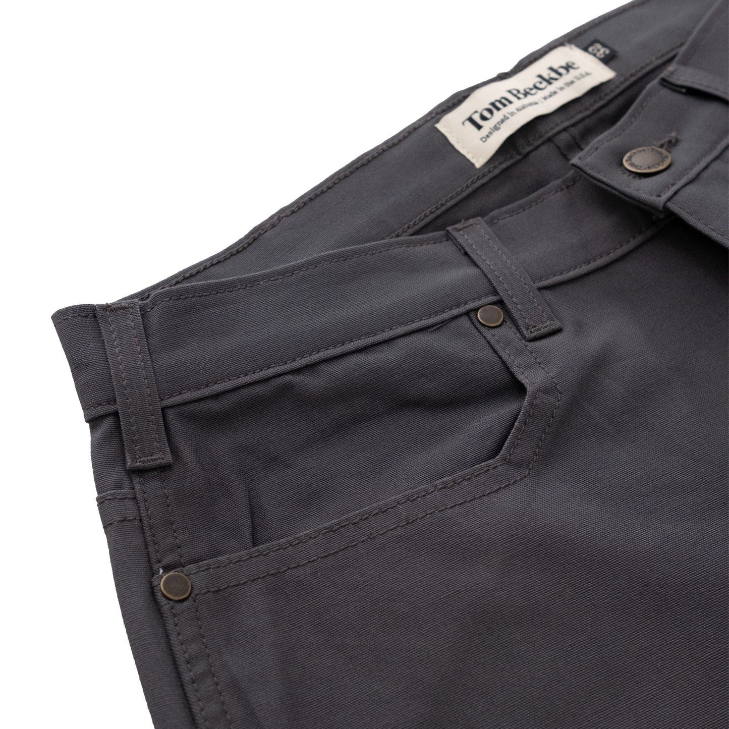 Tom Beckbe Redmont Pant detail shot in durable cotton, showcasing front pockets and waistband label.