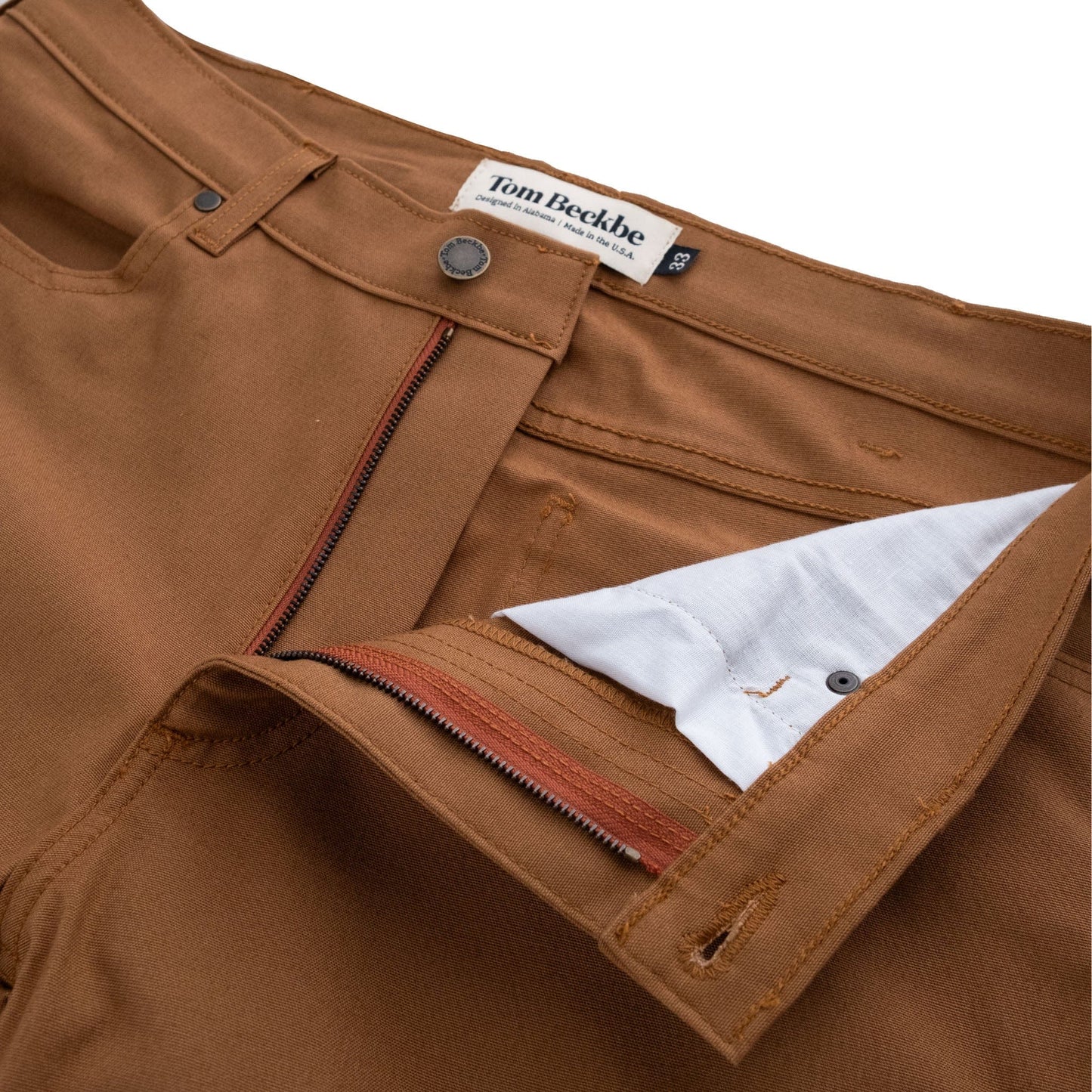 Close-up of the Redmont Pant by Tom Beckbe, featuring a durable cotton zipper and white inner lining, with label on waistband.
