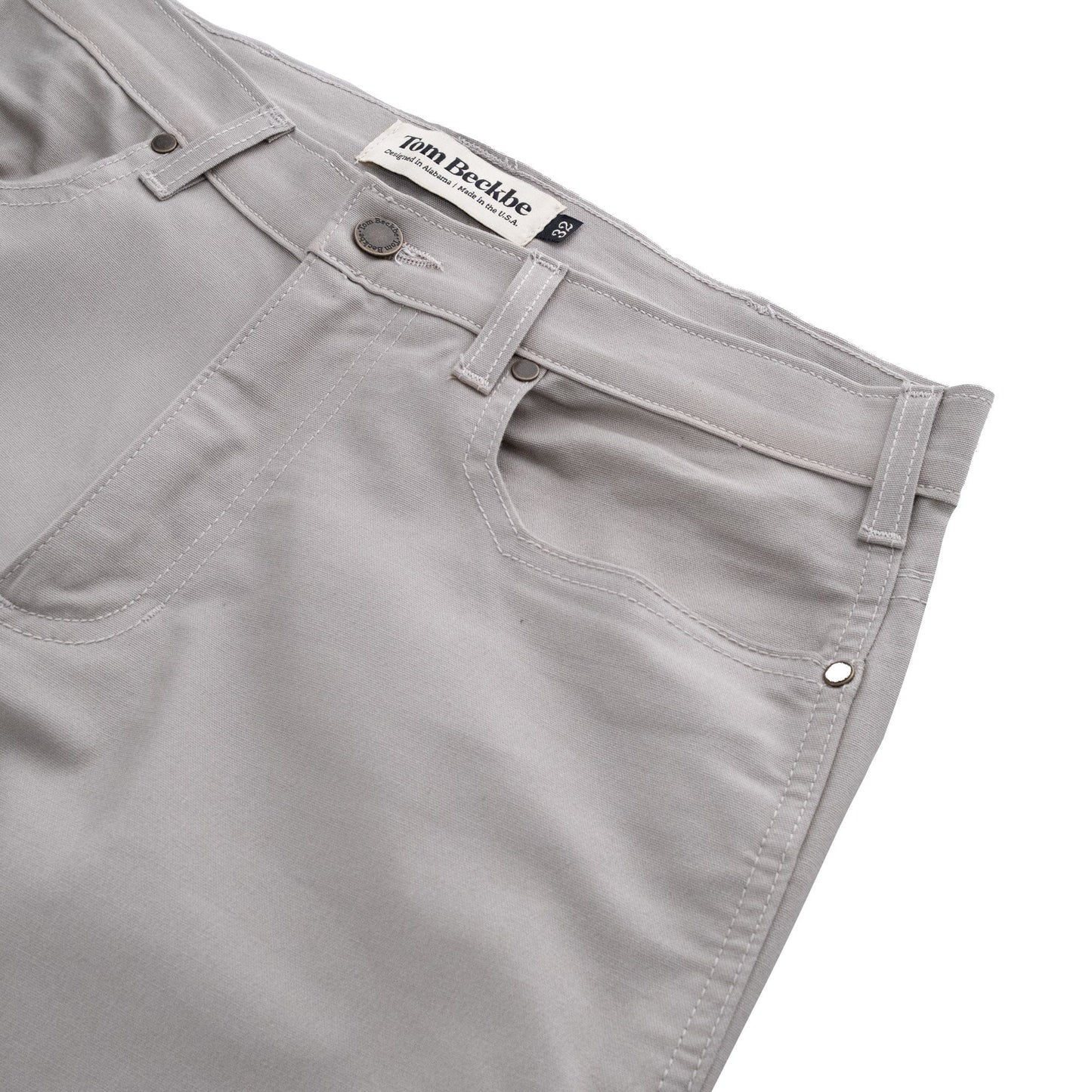 Tom Beckbes Redmont Pant in grey features a front pocket, belt loops, visible waistband label, and is made from durable cotton.