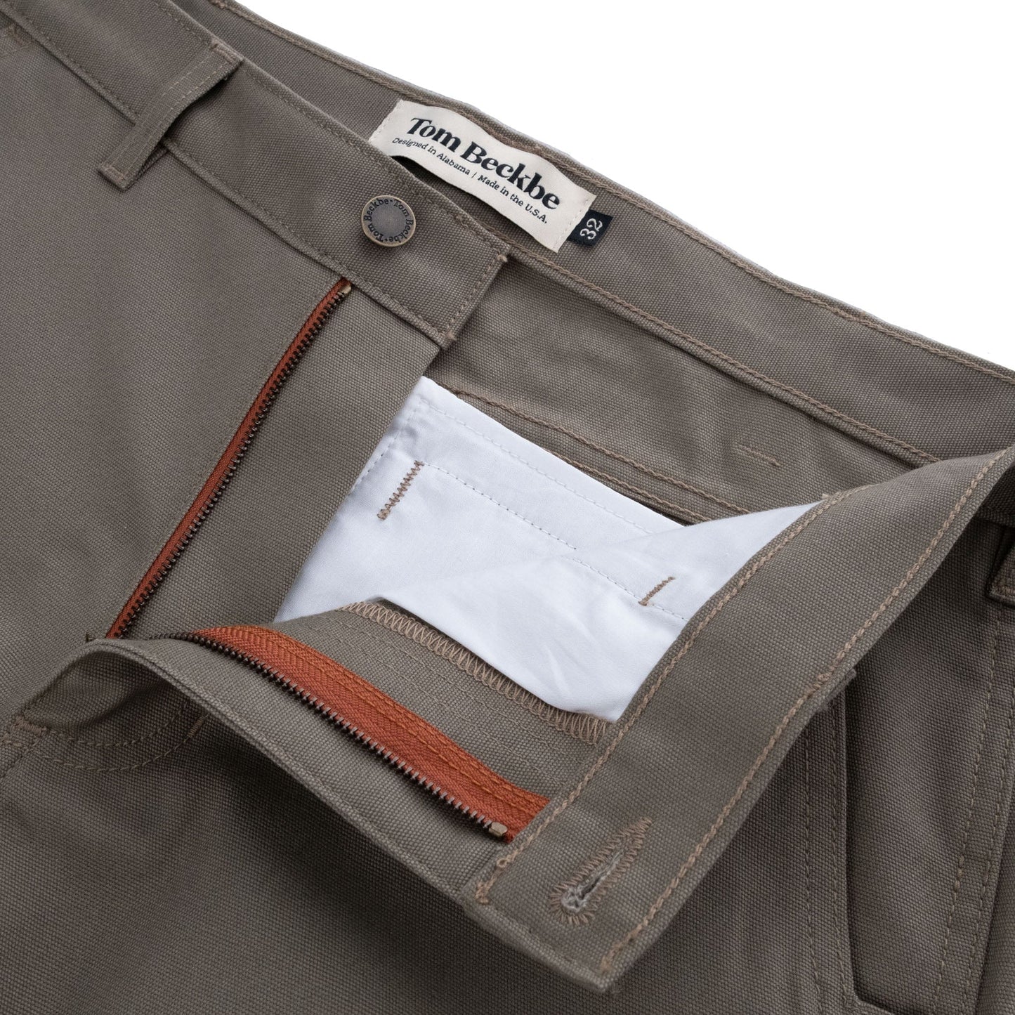 Close-up of durable gray Tom Beckbe Rutledge Double-Front Pant with a brown zipper, brand label partly visible.