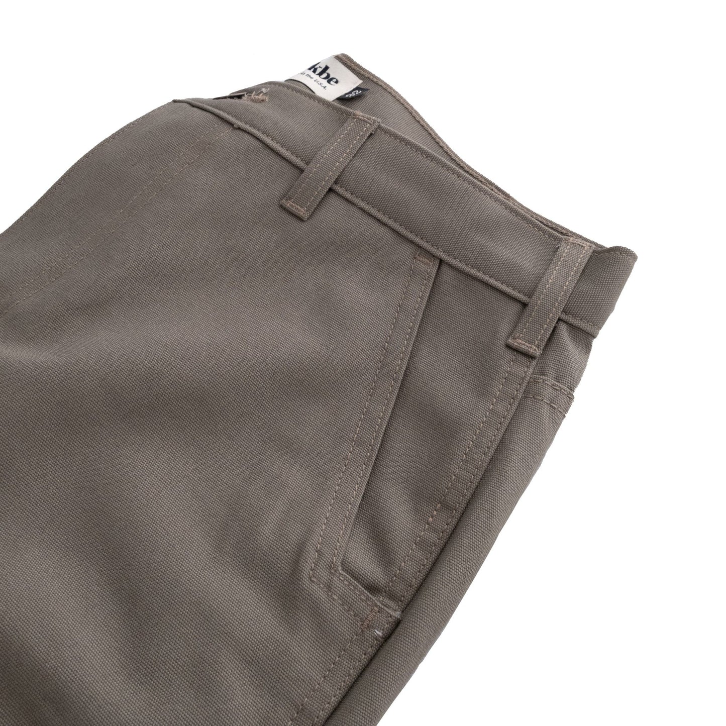 Close-up of Tom Beckbes Rutledge Double-Front Pant in gray with front pockets, belt loops, and a visible waistband label.