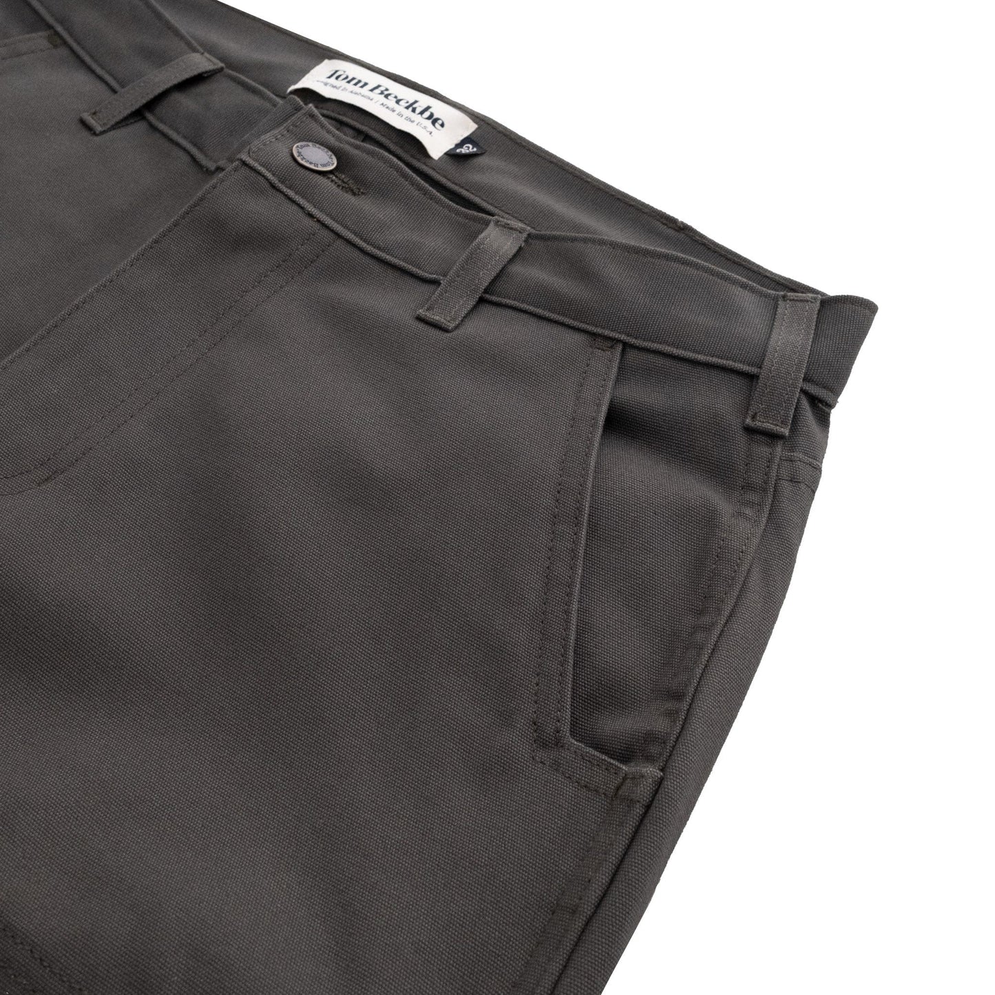 Dark gray Tom Beckbe Rutledge Double-Front Pant in classic fit, with pockets, belt loops, and button closure on white surface.