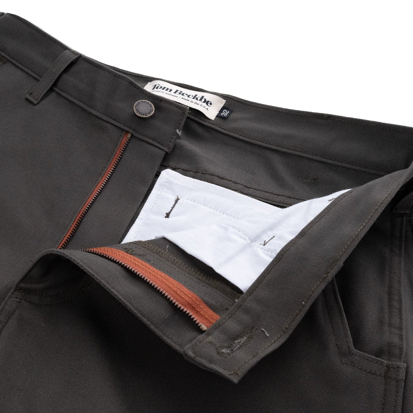 Close-up of open Tom Beckbe Rutledge Double-Front Pant, revealing the label, zipper, inner lining, and pocket.