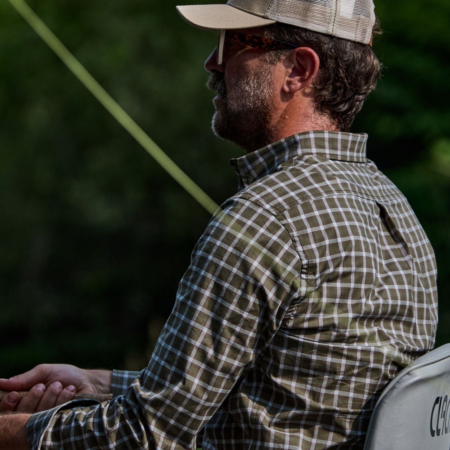 Man outdoors in a Tom Beckbe Tidewater Shirt, left-facing with trees behind him.