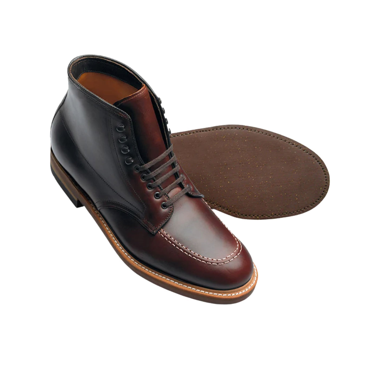 A pair of Tom Beckbe Alden #403 Indy Boots in brown leather, one upright, one sole up, on a white background.