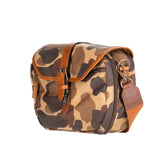 Tom Beckbes Classic Camo Blind Bag features a camo pattern, brown leather accents, a leather-bound opening, and an adjustable strap.