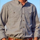 Man wearing Tom Beckbe Dixon Brushed Cotton Twill Shirt in light gray with two chest pockets and brown belt outdoors.