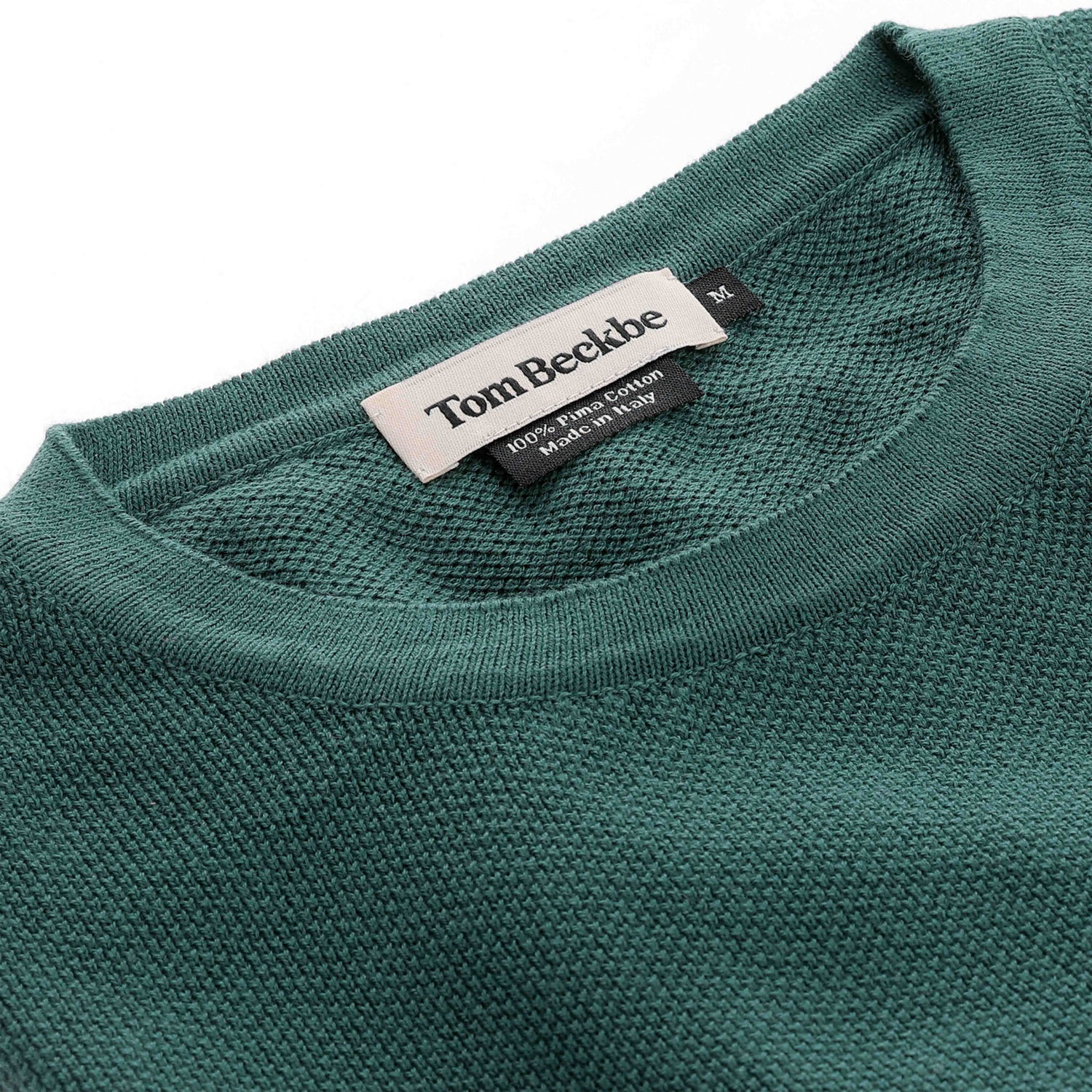 Close-up of a green Foley Pima Crewneck Sweater for men with a visible Tom Beckbe label at the neckline.