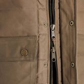 Close-up of the Tom Beckbe Fowler Vest: brown, weatherproof, metal buttons, zipper, and two fabric pockets.