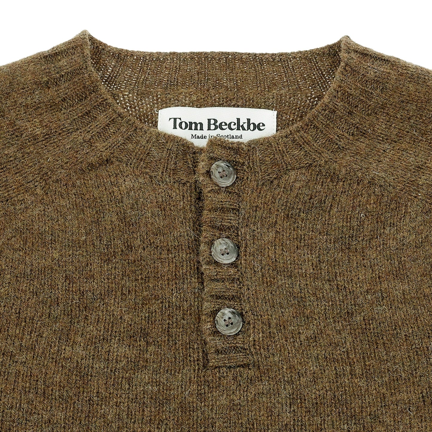 Close-up of the Tom Beckbe Albemarle Henley Sweater in brown wool with three buttons and a label at the neckline.
