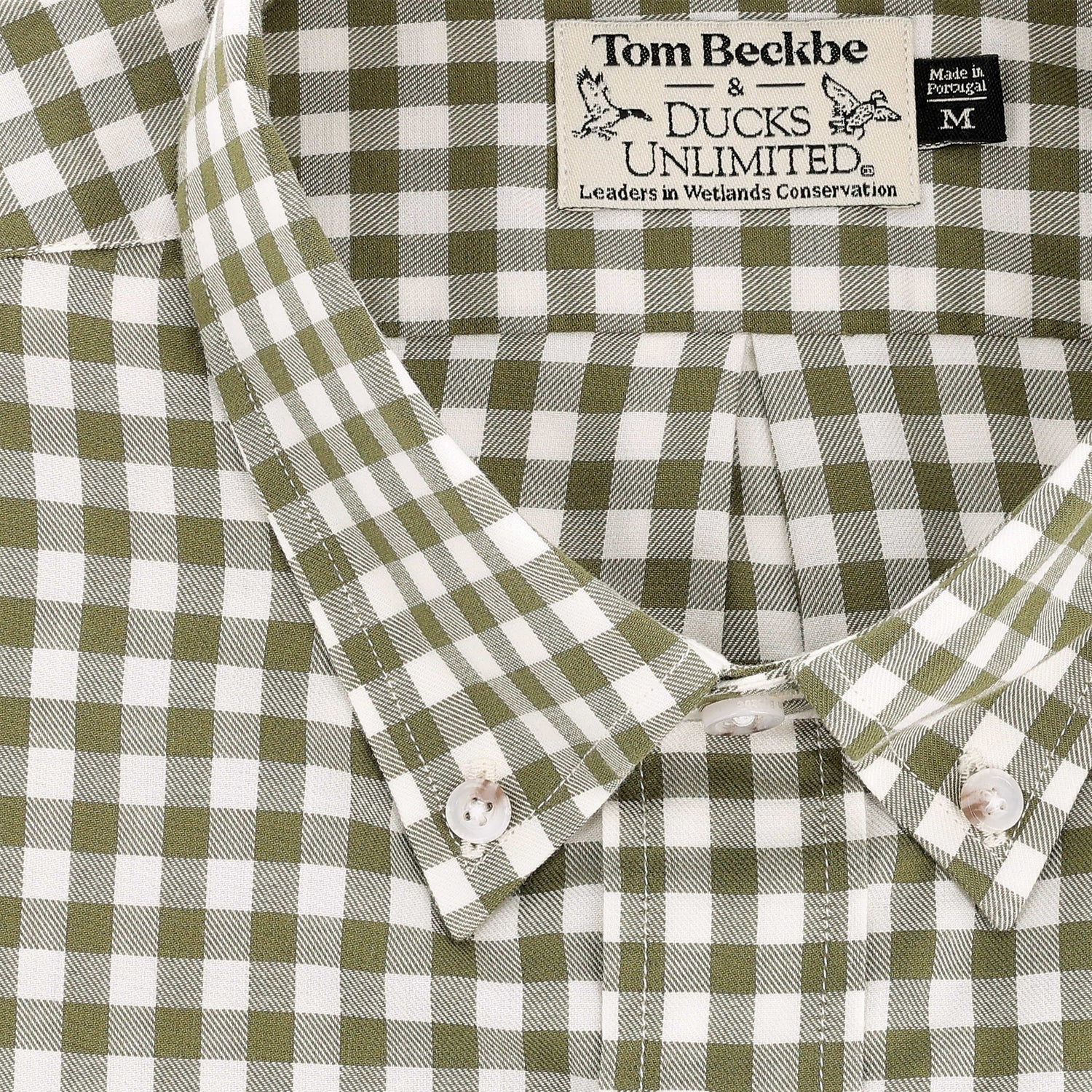 Close-up of a green and white checkered Knapp Cotton Twill Shirt by Tom Beckbe with a visible brand label.