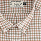 Close-up of a brown, tan, and white plaid button-down shirt with a Tom Beckbe & Ducks Unlimited label.