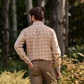 A man stands outdoors among trees wearing the Tom Beckbe Dixon Brushed Cotton Twill Shirt and brown pants.