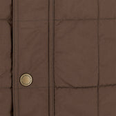 Close-up of the Tom Beckbe Burgess Quilted Vest for men, featuring visible stitched lines and a Loro Piana button.