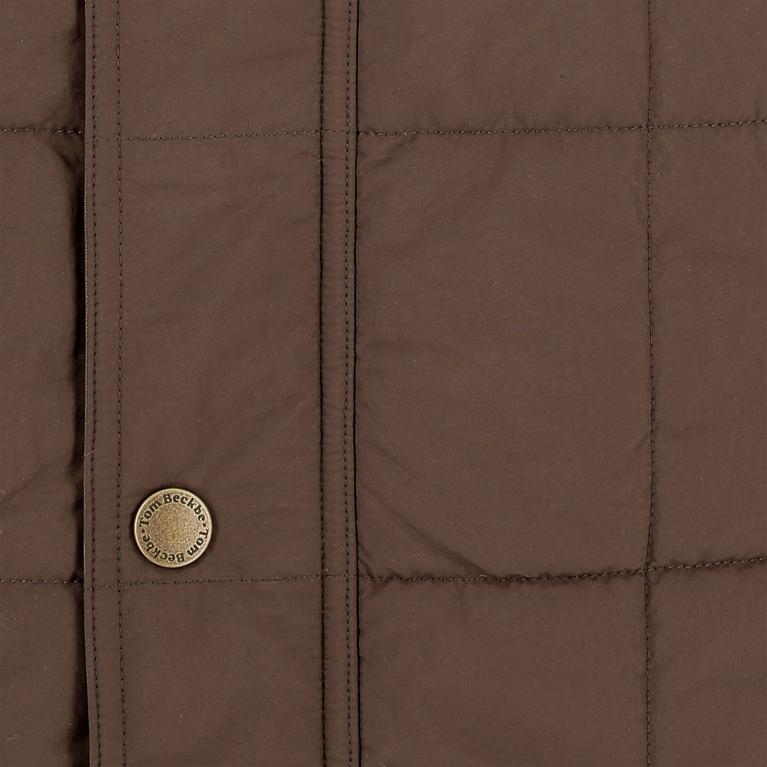 Close-up of the Tom Beckbe Burgess Quilted Vest for men, featuring visible stitched lines and a Loro Piana button.