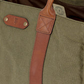 Close-up of an olive green Tom Beckbe Canvas Carryall Bag with brown leather handles and branded leather patch.