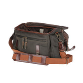 Tom Beckbes Canvas Field Bag in green/brown has multiple pockets, zippers, and an adjustable shoulder strap.