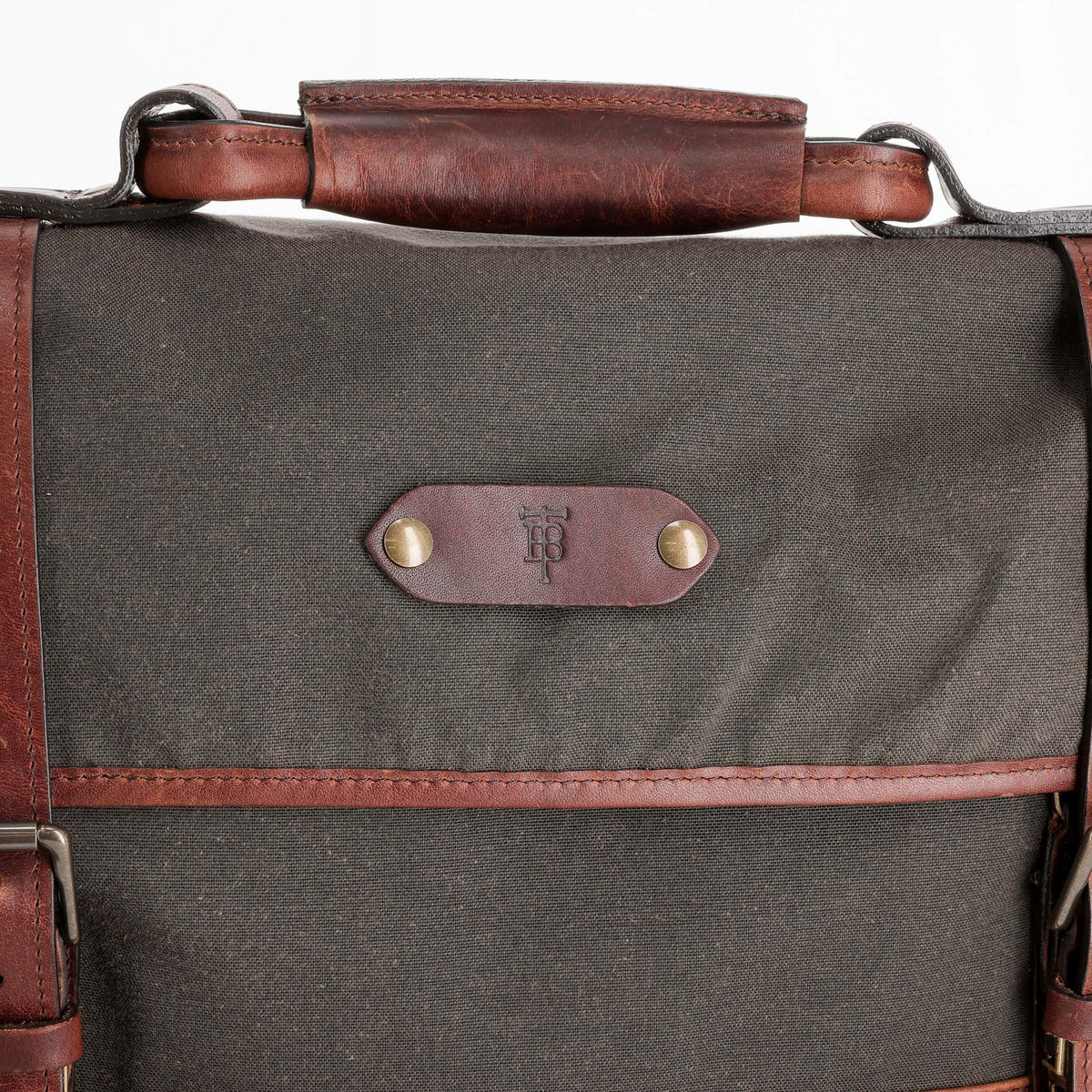 Tom Beckbe Messenger Bag: dark green waxed canvas, brown leather handle, brass rivets, front padded laptop sleeve.