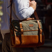 Person carrying a green Tom Beckbe Messenger Bag, wearing a white shirt.
