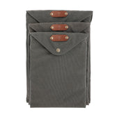 Three gray Canvas Portfolios by Tom Beckbe, weatherproof with leather tabs and snap closures, stacked together.