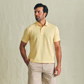 Man wears a Tom Beckbe Coastal Polo Shirt and beige shorts against a plain light background.