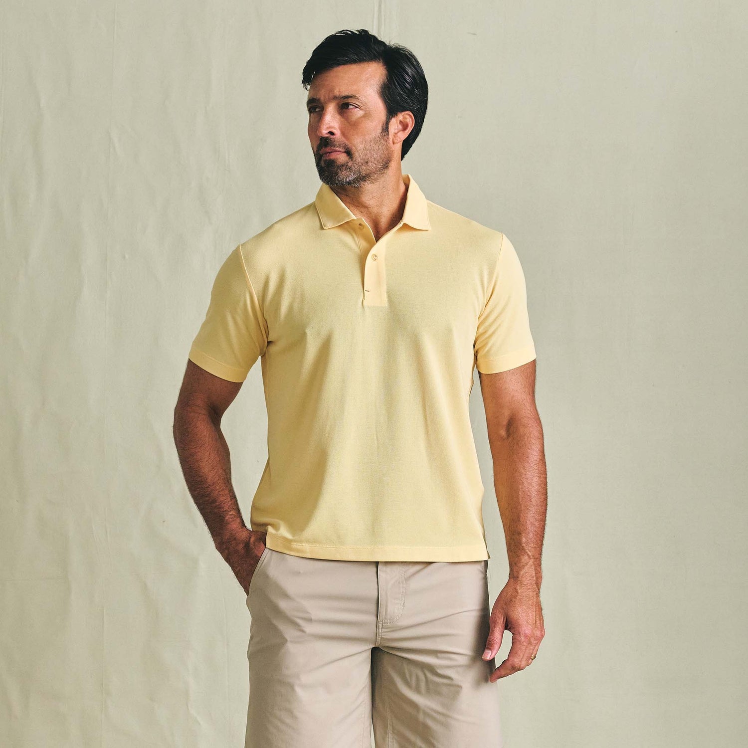 Man wears a Tom Beckbe Coastal Polo Shirt and beige shorts against a plain light background.