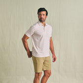 Man in Tom Beckbe Crenshaw Performance Short and striped polo stands against a plain background, looking to the side.