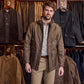 A man stands in a store with Tom Beckbe Culver Oxford Shirts hanging on racks behind him.