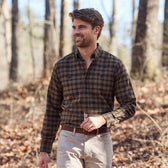 A man in a Tom Beckbe Dixon Brushed Cotton Twill Shirt and beige pants walks outdoors among dry leaves.