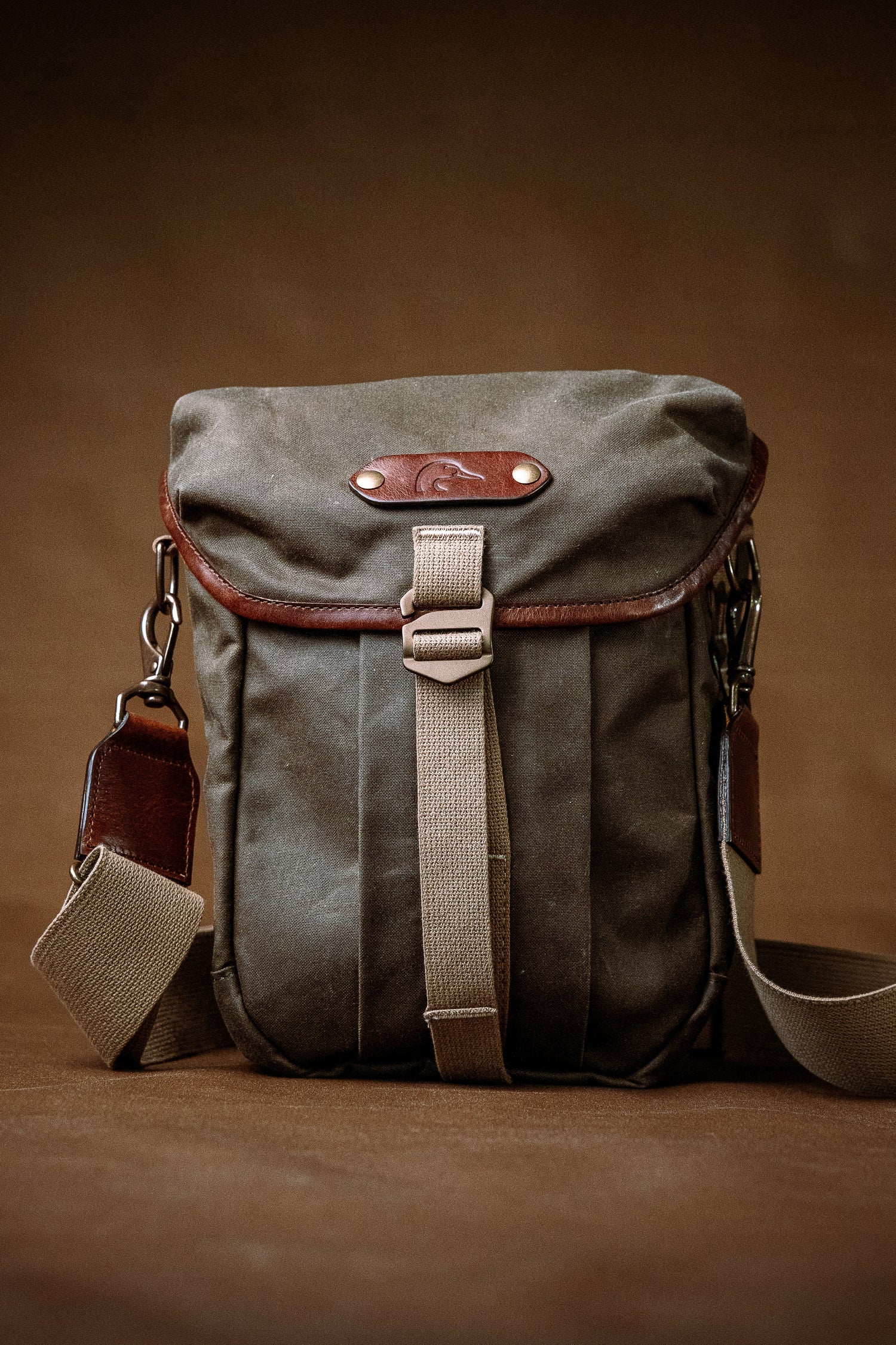 Vintage-style leather and canvas bag on a brown background