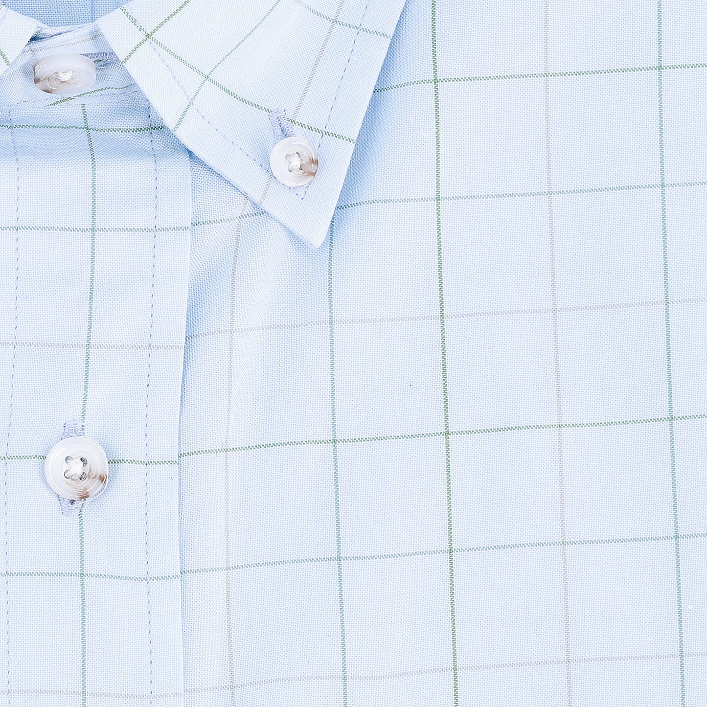 Close-up of the Ensley Pinpoint Oxford Shirt by Tom Beckbe in light blue with green and gray checks and white buttons.
