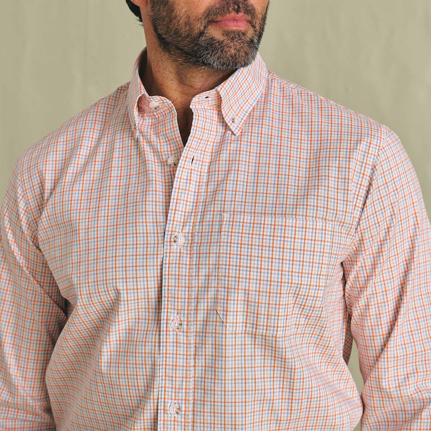 Man in Tom Beckbe Ensley Pinpoint Oxford Shirt, light orange/blue, shown chest up on neutral background.