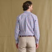 Man facing away in a Tom Beckbe Ensley Pinpoint Oxford Shirt, beige pants, on a plain tan background.