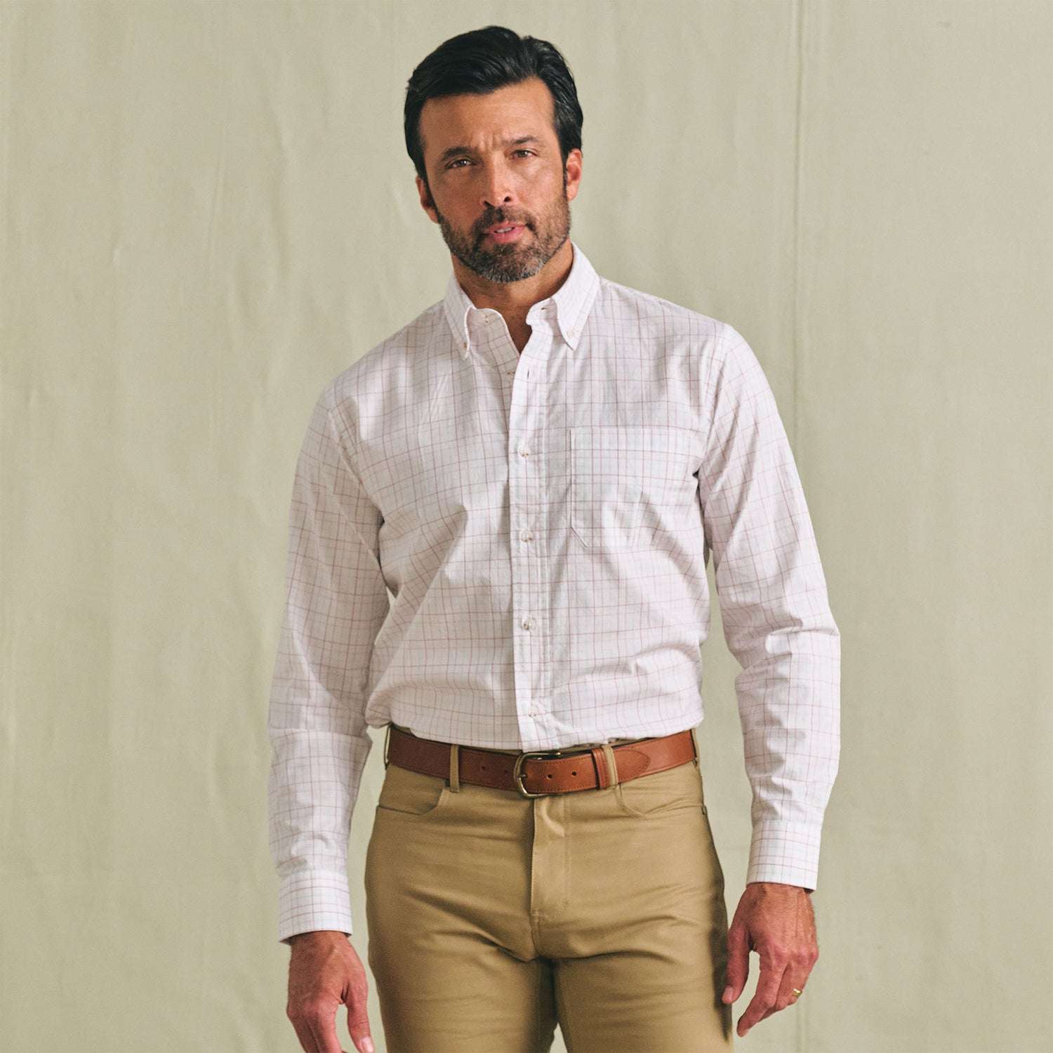Man in a Tom Beckbe Ensley Pinpoint Oxford Shirt and khaki pants with a brown belt, against a plain background.