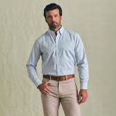Man facing forward wears the Tom Beckbe Ensley Pinpoint Oxford Shirt in light blue with beige pants and brown belt.