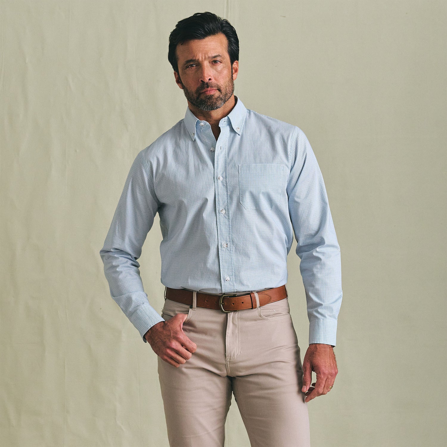 Man facing forward wears the Tom Beckbe Ensley Pinpoint Oxford Shirt in light blue with beige pants and brown belt.