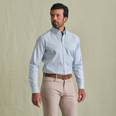 Man in a Tom Beckbe Ensley Pinpoint Oxford Shirt stands against a plain background, looking to the side.