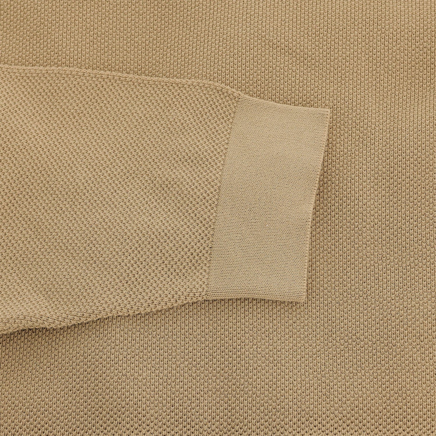 Close-up of the Tom Beckbe Foley Pima Crewneck Sweater, beige cotton with ribbed cuff, on a matching background.