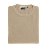 The Tom Beckbe Foley Pima Crewneck Sweater in beige is neatly folded with the label visible on a white background.