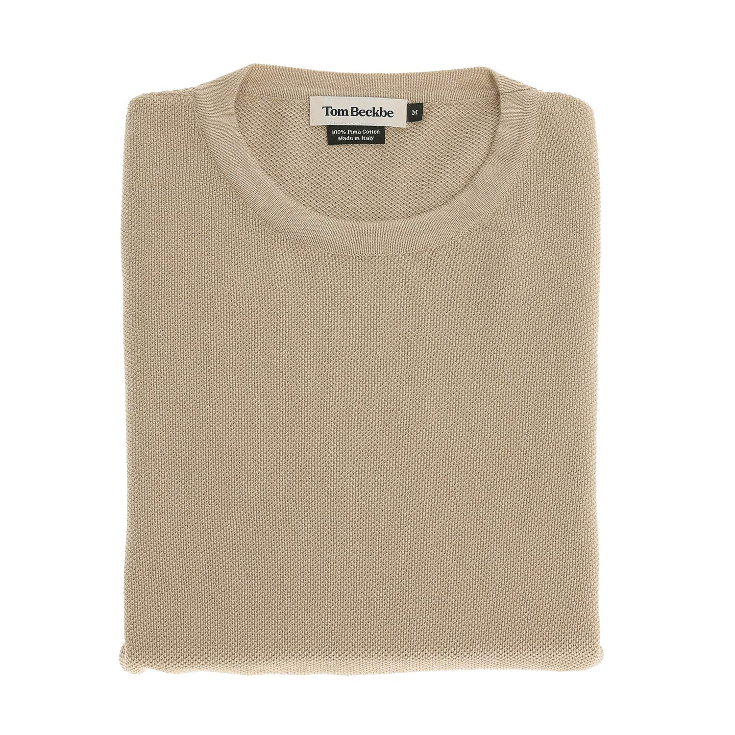 The Tom Beckbe Foley Pima Crewneck Sweater in beige is neatly folded with the label visible on a white background.