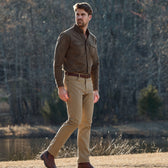 A man in a Tom Beckbe Hartwell Moleskin Shirt stands outdoors near trees and a pond.