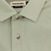 Close-up of the light green Hutton Performance Polo by Tom Beckbe, featuring two buttons on the placket.