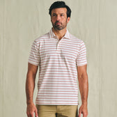 Man wearing a Tom Beckbe Hutton Performance Polo, short-sleeve white with red stripes, and khaki pants.