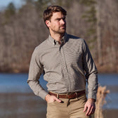 Man by a lake in Tom Beckbes Knapp Cotton Twill Shirt, khaki pants, trees behind him.