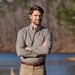 Man in Tom Beckbe Knapp Cotton Twill Shirt and khakis stands outdoors by water and trees, arms crossed.