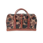 The Tom Beckbe Classic Camo Weekender Duffel Bag with brown leather trim is shown on a white background.