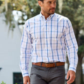 Man wearing a Monroe Poplin Shirt by Tom Beckbe with dark grey pants near a white building.