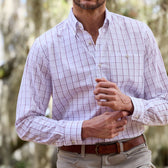 Wearing a Monroe Poplin Shirt by Tom Beckbe, a person adjusts a cufflink with both hands outside.